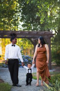 Happy family enjoying a sunny day outdoors in Spring Hill, Florida, surrounded by lush greenery and blooming flowers.