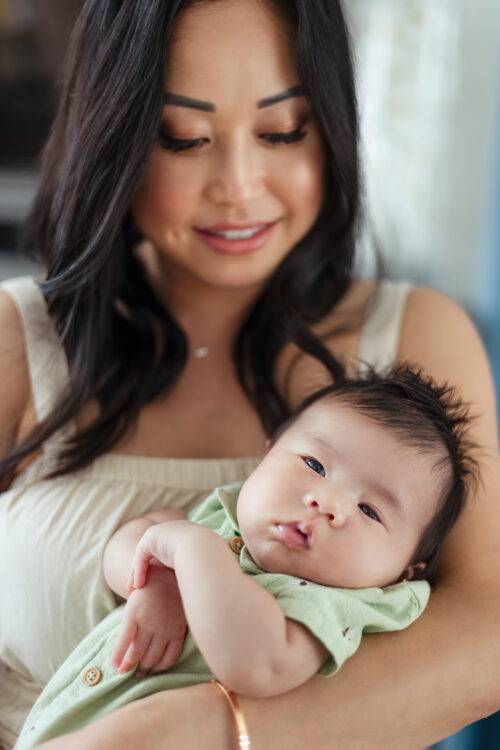 Mother holding her baby while smiling, captured by JCenteno Photography in Tampa, FL